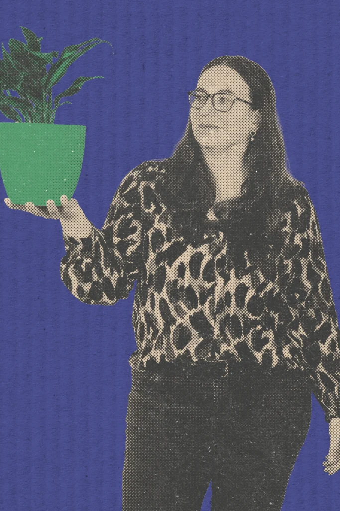 Teammitglied Kira hält eine Pflanze in Grün